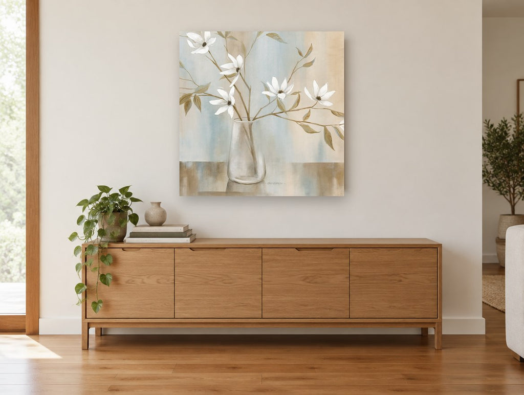 White Magnolia Stems in Glass floral canvas print on the wall of a living room above a sideboard