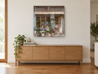 Blue Fleuriste Storefront floral canvas print on the wall of a living room above a sideboard