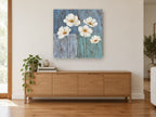 White Poppies on Blue floral canvas print on the wall of a living room above a sideboard