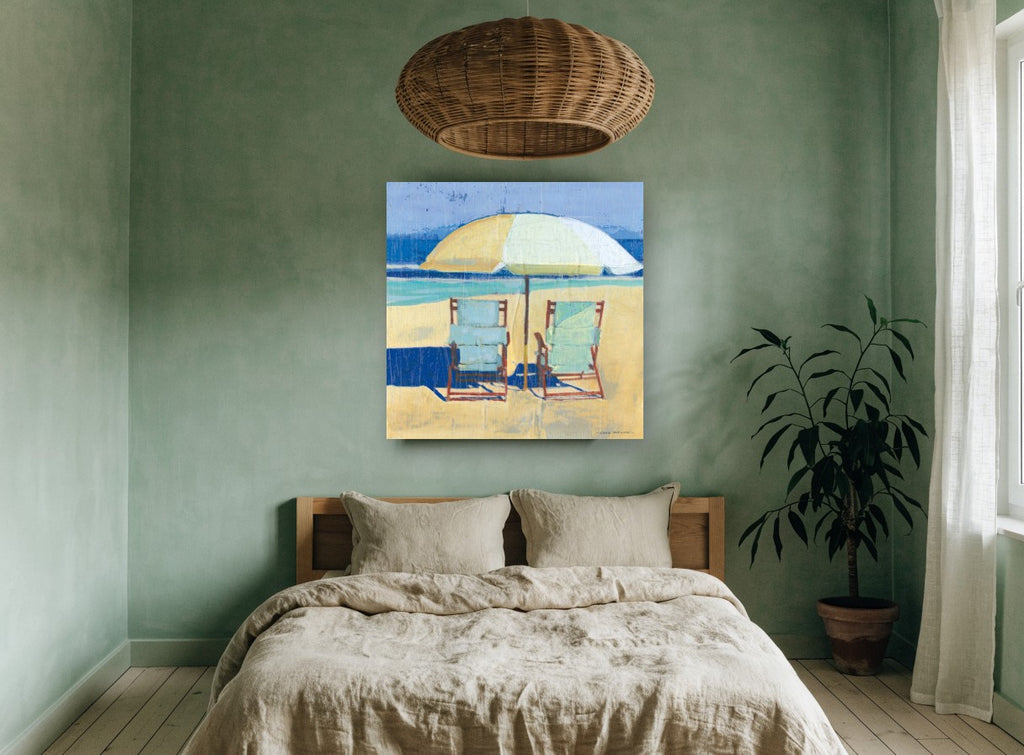 Two Chairs Beneath Umbrella coastal canvas print on the wall of a bedroom