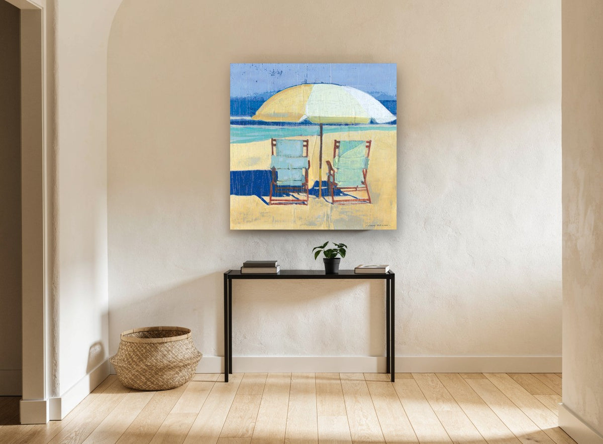 Two Chairs Beneath Umbrella coastal canvas print on the wall of a hallway