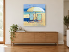 Two Chairs Beneath Umbrella coastal canvas print on the wall of a living room above a sideboard