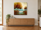 Amber Trees Beside Still Water landscape canvas print on the wall of a living room above a sideboard