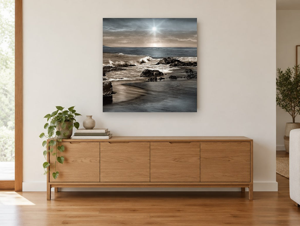 Silver Sun Rocky Shore coastal canvas print on the wall of a living room above a sideboard