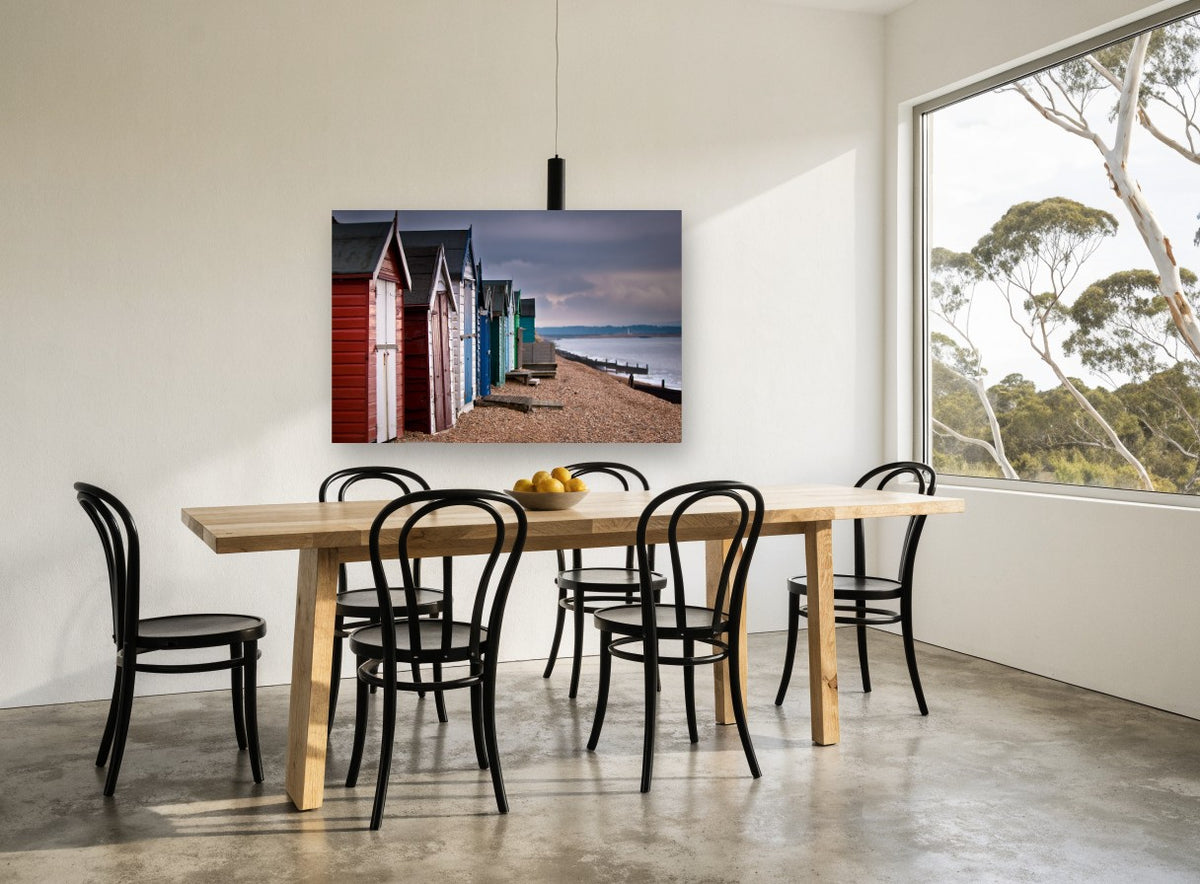 Stormlight Beach Huts coastal canvas print on the wall of a dining room