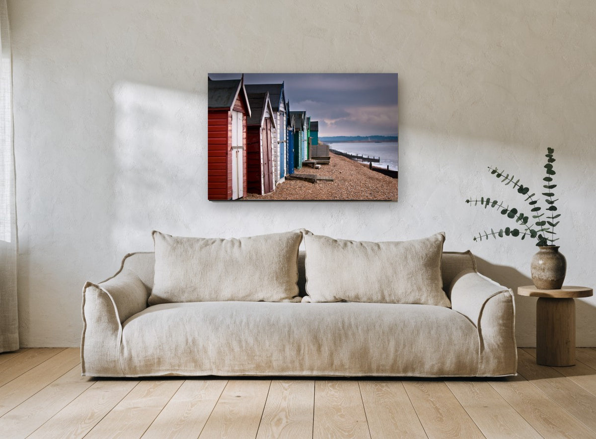 Stormlight Beach Huts coastal canvas print on the wall of a living room