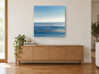 Silver Blue Horizon coastal canvas print on the wall of a living room above a sideboard