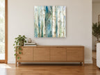 Teal Birch Hush landscape canvas print on the wall of a living room above a sideboard