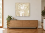 White Daisy on Pale Timber floral canvas print on the wall of a living room above a sideboard
