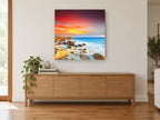 Ember Sky Rocky Cove coastal canvas print on the wall of a living room above a sideboard