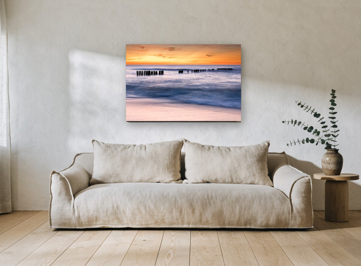 Sunset Pier Posts coastal canvas print on the wall of a living room