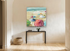 Striped Umbrellas on Sand coastal canvas print on the wall of a hallway