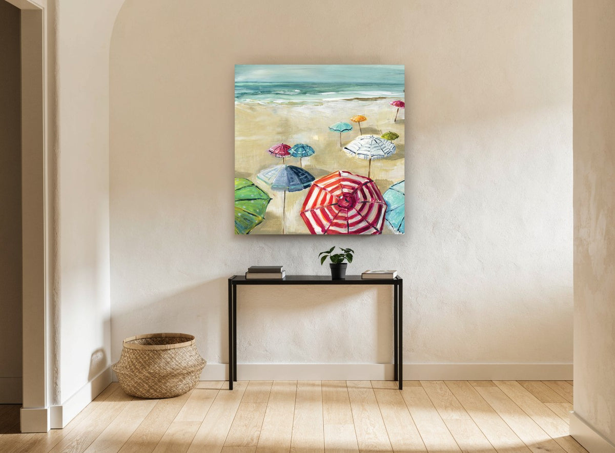 Striped Umbrellas on Sand coastal canvas print on the wall of a hallway