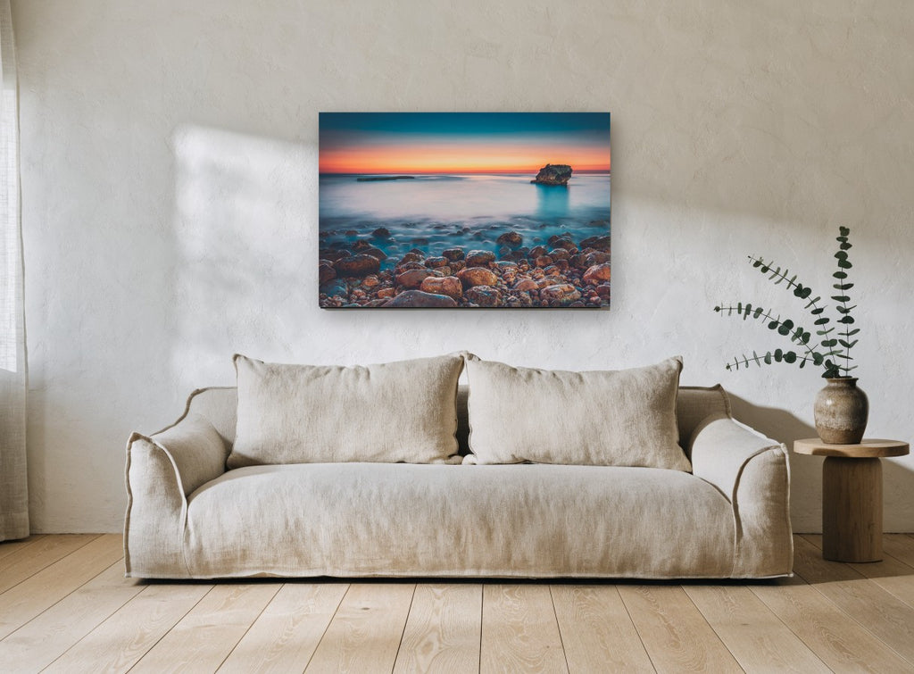 Pebble Shore Afterglow coastal canvas print on the wall of a living room