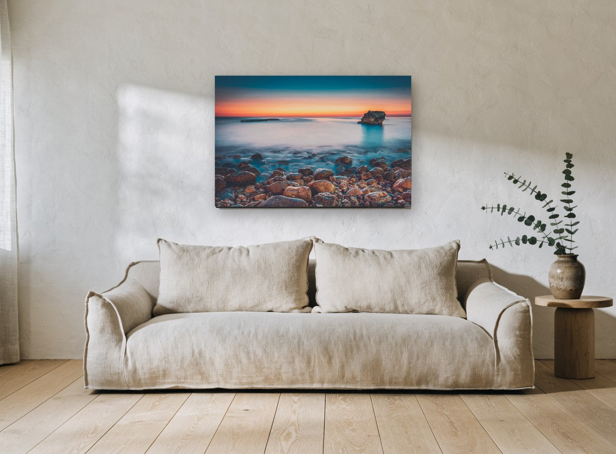Pebble Shore Afterglow coastal canvas print on the wall of a living room