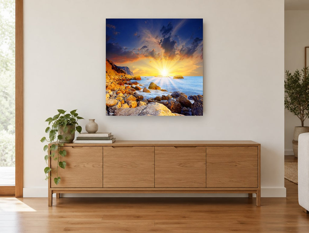 Sunburst Over Rocky Shore coastal canvas print on the wall of a living room above a sideboard