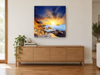 Sunburst Over Rocky Shore coastal canvas print on the wall of a living room above a sideboard