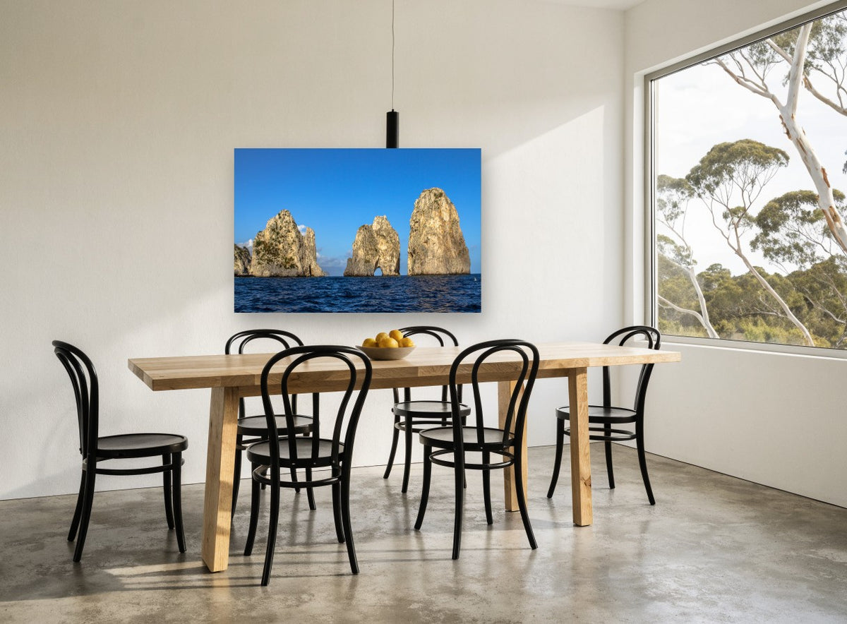 Three Sunlit Sea Stacks coastal canvas print on the wall of a dining room
