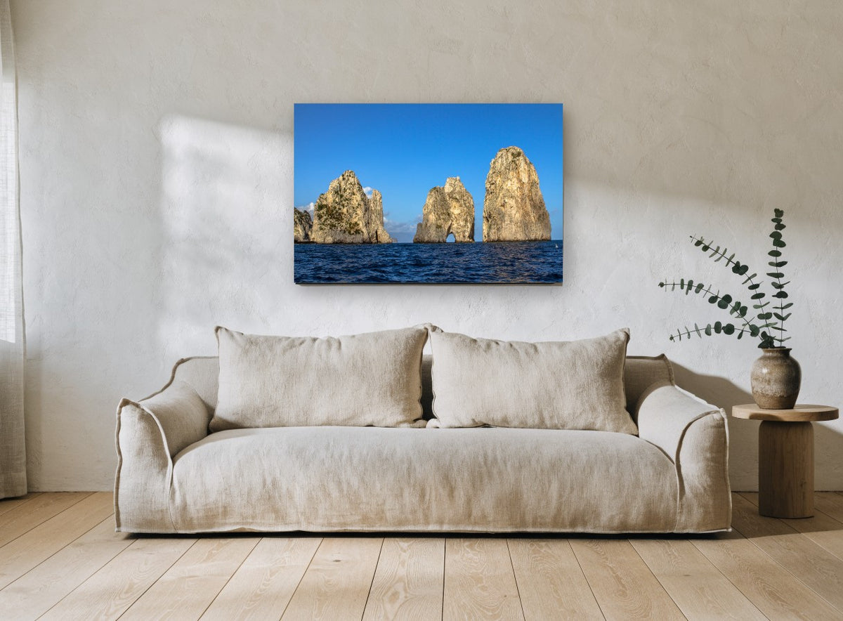 Three Sunlit Sea Stacks coastal canvas print on the wall of a living room