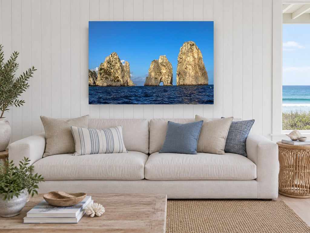 Three Sunlit Sea Stacks coastal canvas print on the wall of a beach house living room