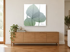 Sage Leaf Veils floral canvas print on the wall of a living room above a sideboard