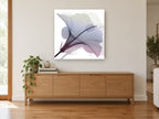 Misted Hibiscus Bloom floral canvas print on the wall of a living room above a sideboard