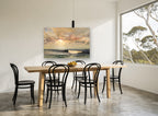Golden Light Over Waves coastal canvas print on the wall of a dining room