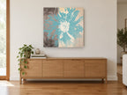 Teal Bloom Divide floral canvas print on the wall of a living room above a sideboard