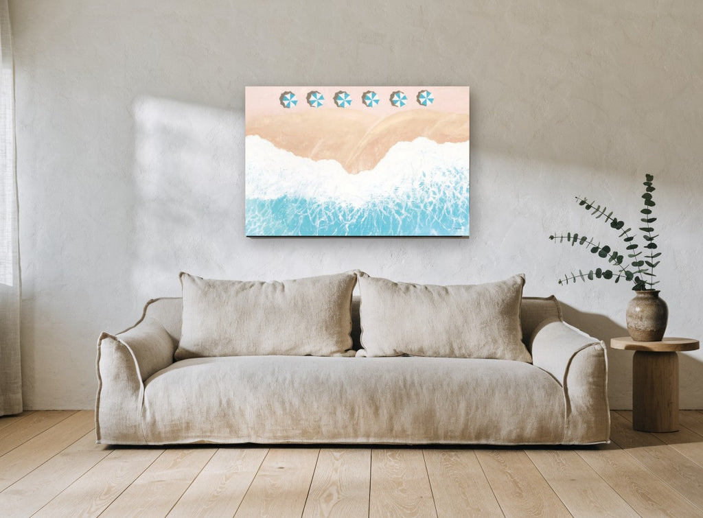 Pink Sand Umbrella Row coastal canvas print on the wall of a living room