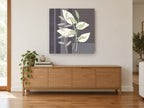 Sage and Cream Leaves floral canvas print on the wall of a living room above a sideboard