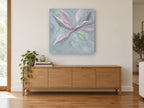 Dusky Magnolia Bloom floral canvas print on the wall of a living room above a sideboard
