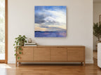 Dawn Over Violet Water coastal canvas print on the wall of a living room above a sideboard
