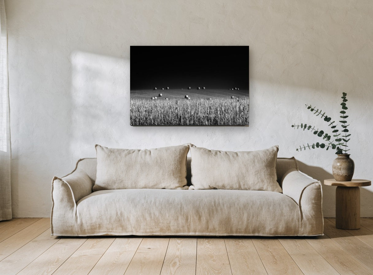 Bales Under Dark Sky landscape canvas print on the wall of a living room