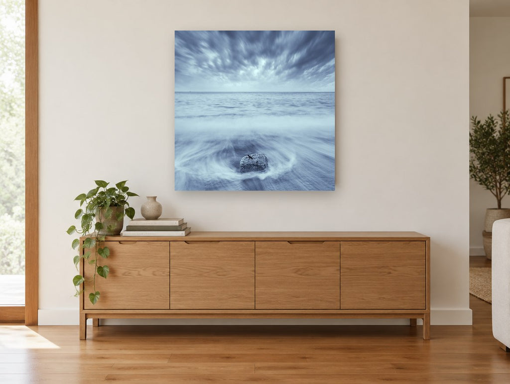 Stone in the Swirl coastal canvas print on the wall of a living room above a sideboard