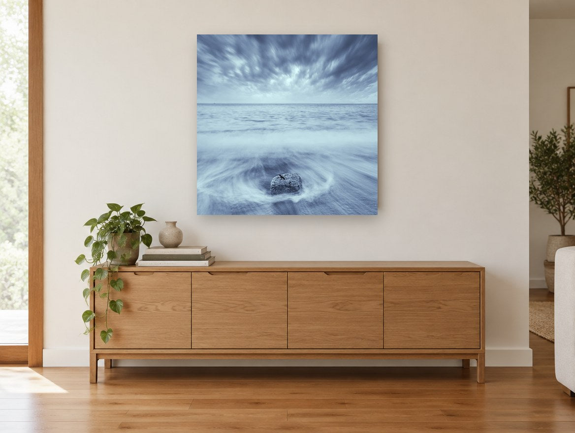 Stone in the Swirl coastal canvas print on the wall of a living room above a sideboard