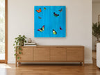 Butterflies on Cerulean animal canvas print on the wall of a living room above a sideboard
