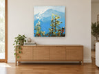 Blue Peak Through Pines landscape canvas print on the wall of a living room above a sideboard