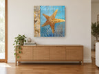 Golden Starfish Seashore coastal canvas print on the wall of a living room above a sideboard