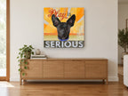Play Is Serious Pup animal canvas print on the wall of a living room above a sideboard