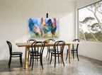 Three Roosters Trio animal canvas print on the wall of a dining room