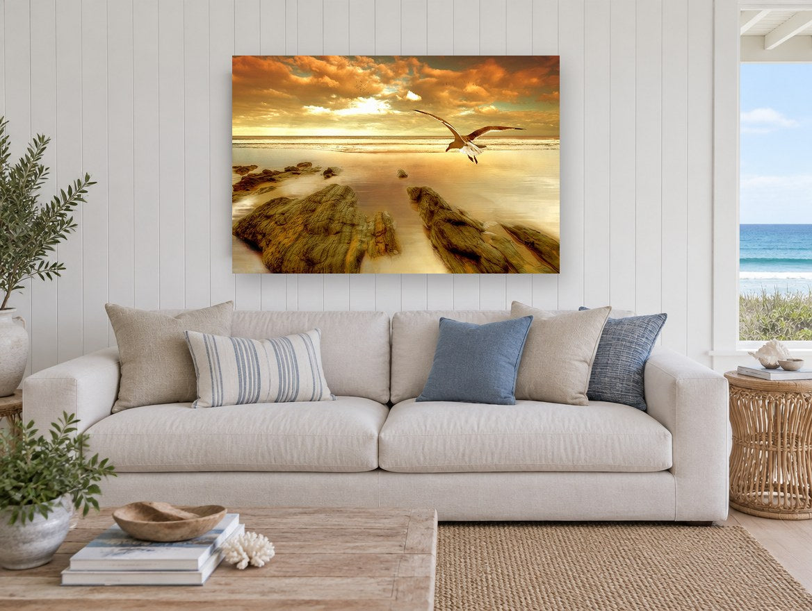 Gull Over Golden Shore coastal canvas print on the wall of a beach house living room