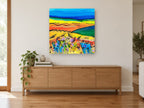 Bright Meadow Hills landscape canvas print on the wall of a living room above a sideboard