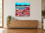 Poppy Shore Meadow coastal canvas print on the wall of a living room above a sideboard