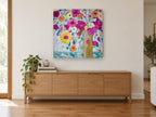 Bright Blooms Tall Vase floral canvas print on the wall of a living room above a sideboard