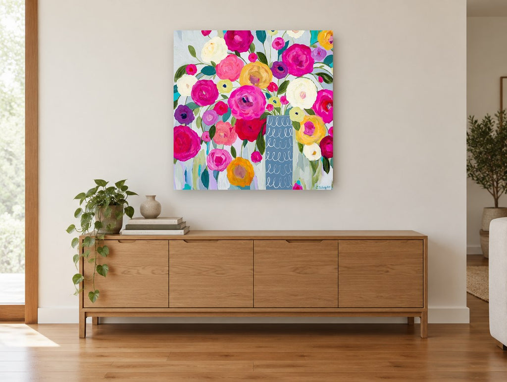 Bright Blooms in Blue Vase floral canvas print on the wall of a living room above a sideboard