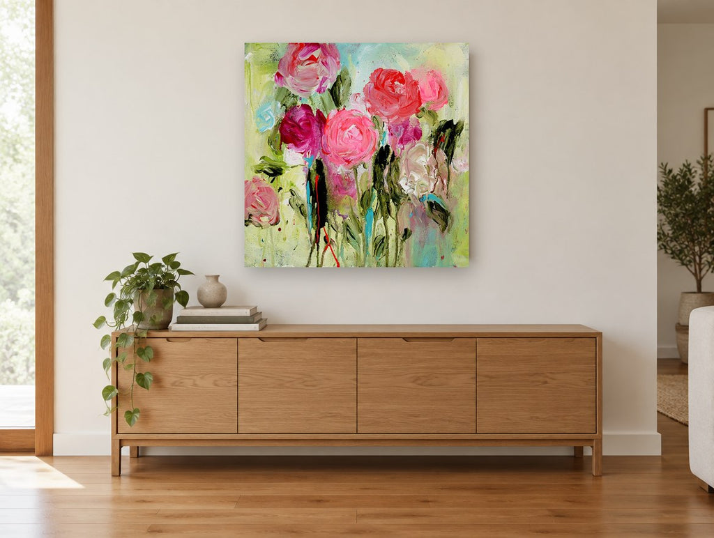 Pink Roses in Motion floral canvas print on the wall of a living room above a sideboard