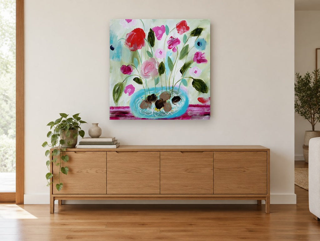 Pink Blooms in Turquoise Bowl floral canvas print on the wall of a living room above a sideboard