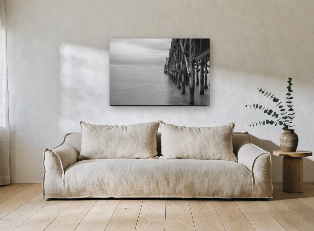 Quiet Pier Pilings coastal canvas print on the wall of a living room