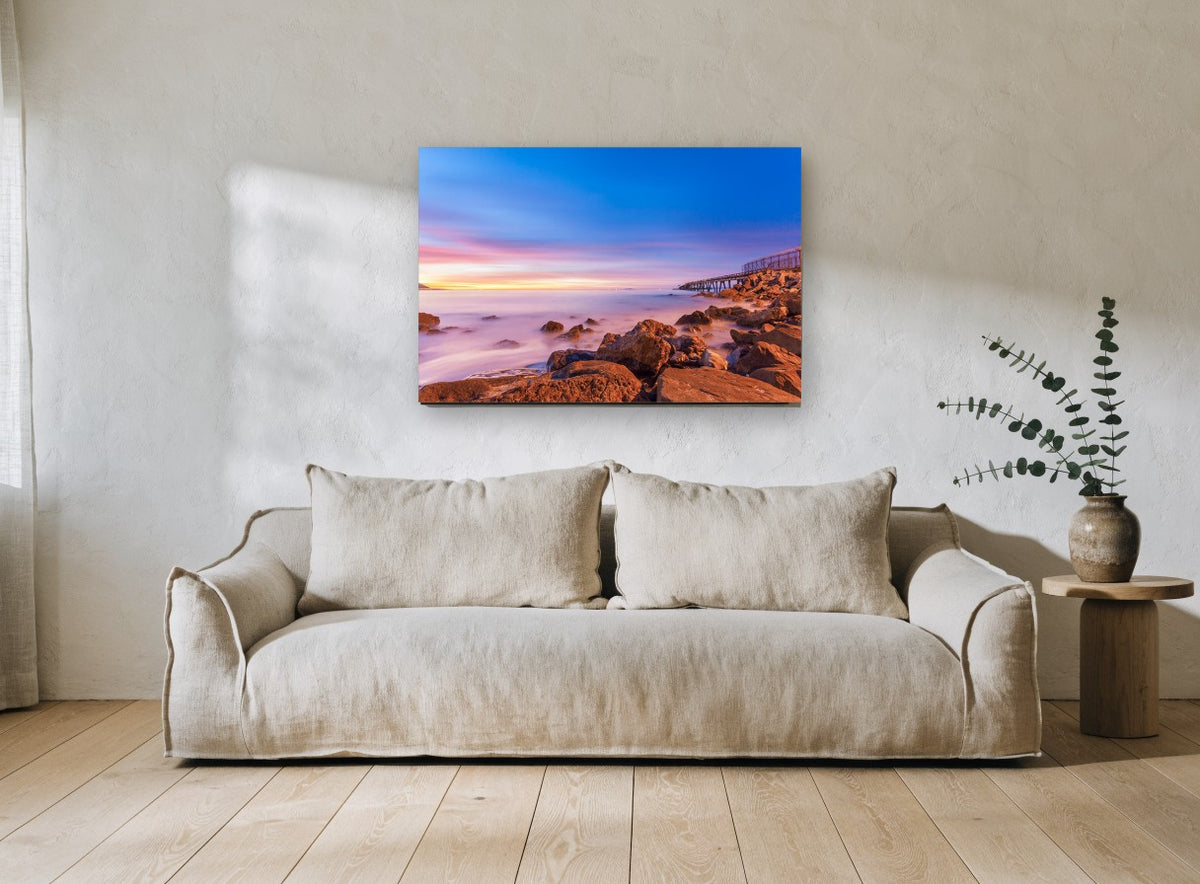 Dusk Over Rocky Shore coastal canvas print on the wall of a living room