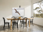 Pelican Over Still Water coastal canvas print on the wall of a dining room